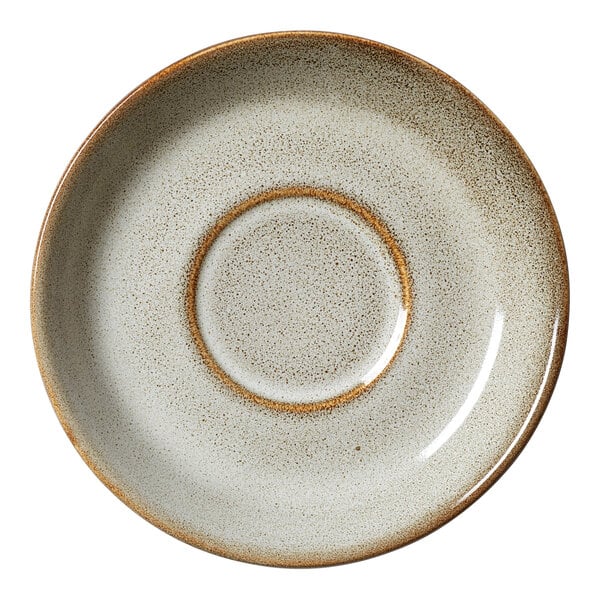 A round, speckled beige porcelain saucer with a slightly raised center, designed for use with cups.