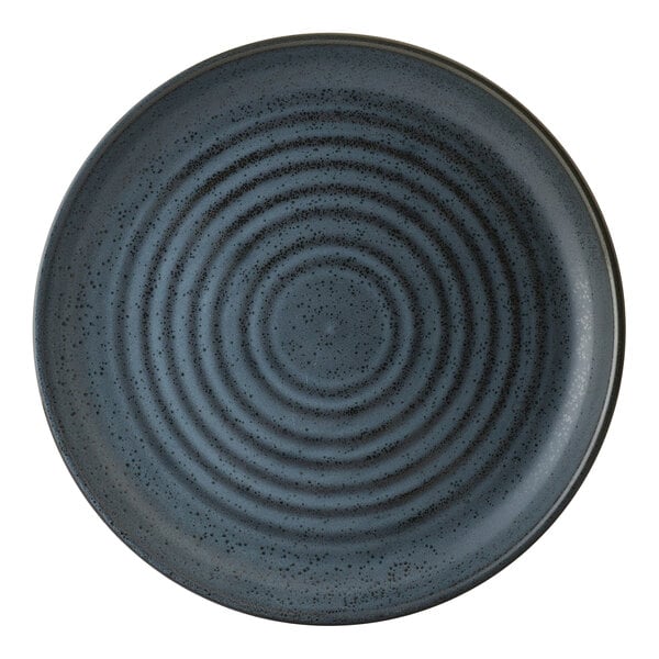 A round, blue porcelain plate with a speckled and concentric ring design.