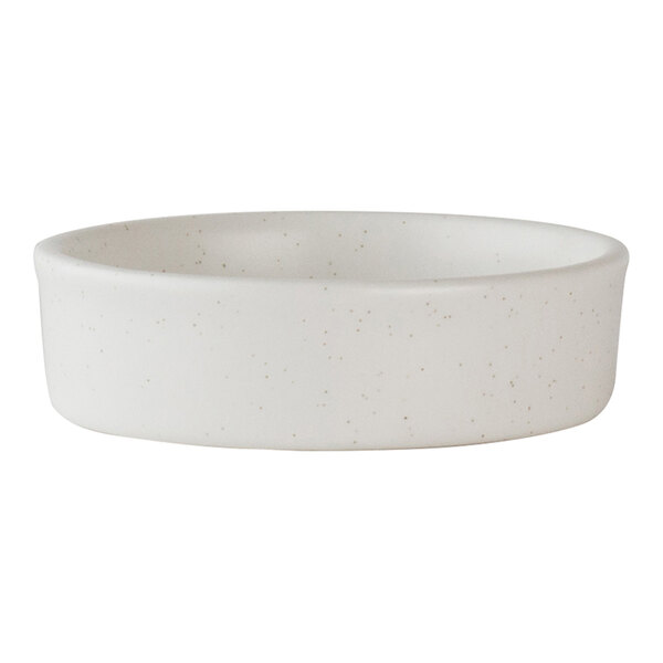 A small, round, white porcelain ramekin or condiment tray with a smooth finish.
