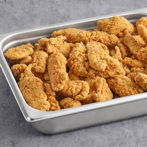 A stainless steel tray filled with breaded and fried grouper tenders.