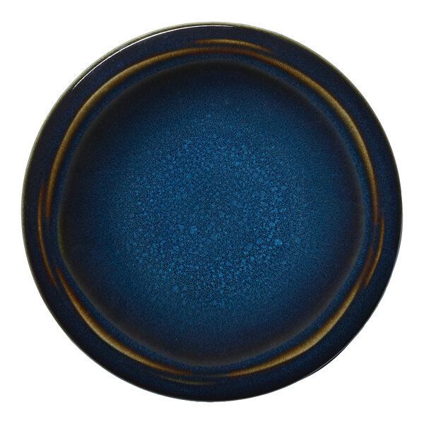 A round blue porcelain coupe flat plate with a speckled design.