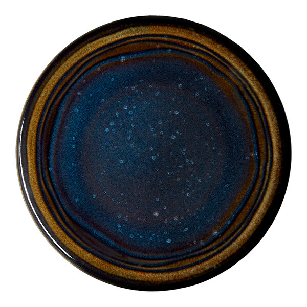 A round blue porcelain coupe flat plate with a speckled and ringed design.