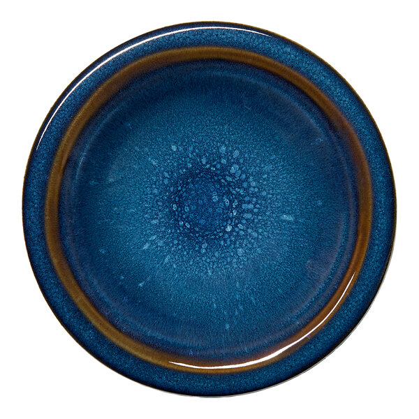 A round blue porcelain coupe flat plate with a textured splash design.