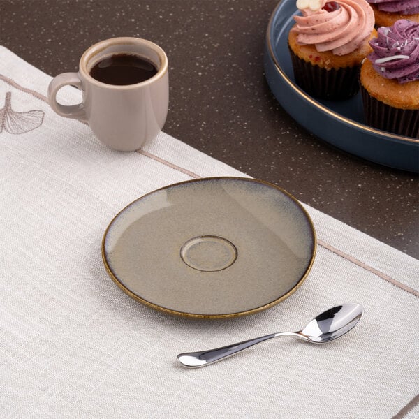 A beige round porcelain coupe espresso cup saucer.