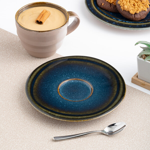 A round blue porcelain coupe saucer with a denim splash design.