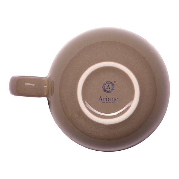 A beige porcelain coffee cup shown upside down with a handle and the Ariane brand logo on the bottom.