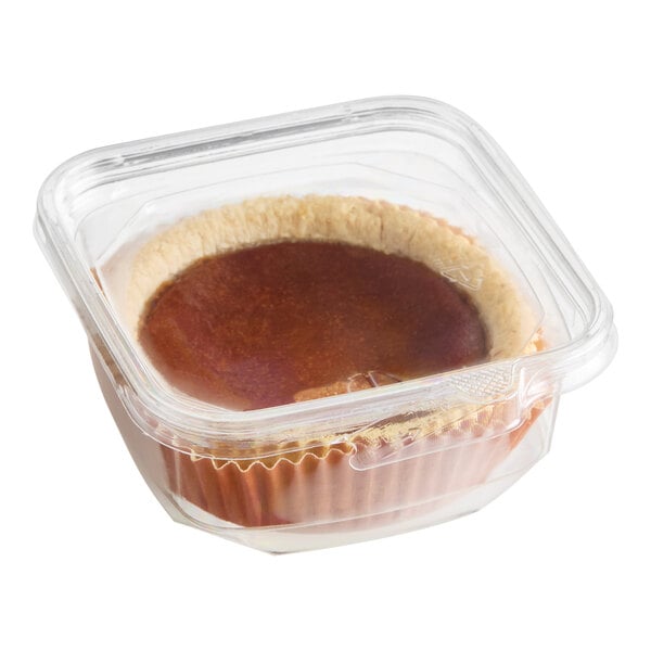 A mini pumpkin pie in a clear plastic container.
