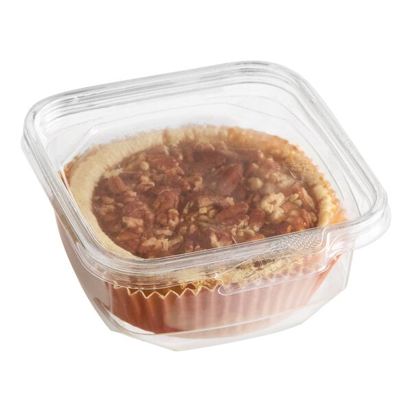 A mini pecan pie in a clear plastic container.