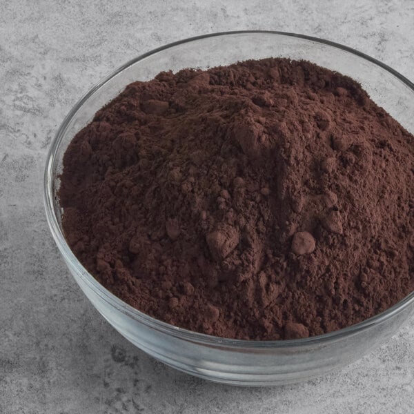 A glass bowl filled with dark brown cocoa powder.