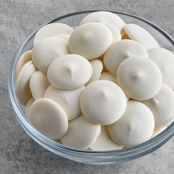 A glass bowl filled with white vanilla compound coating wafers.