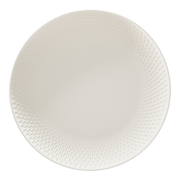 A round white porcelain coupe plate with a subtle textured pattern around the rim.