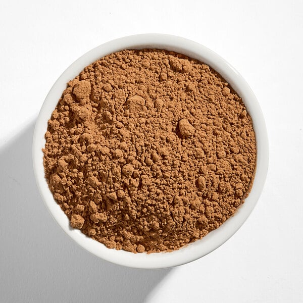A white bowl filled with light brown cocoa powder.