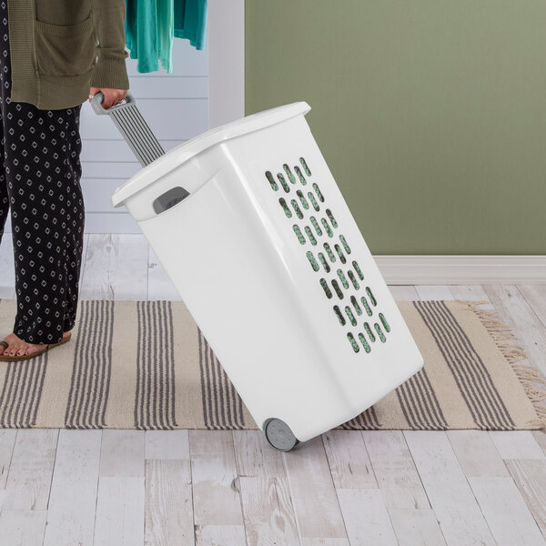 A white rectangular laundry hamper with a flip-top lid and wheels being pulled by a person.