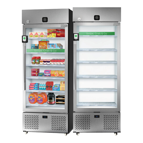 A pair of stainless steel smart pantry vending microstore refrigerators, one stocked with various snacks and household items and the other empty, both featuring glass doors and security cameras.