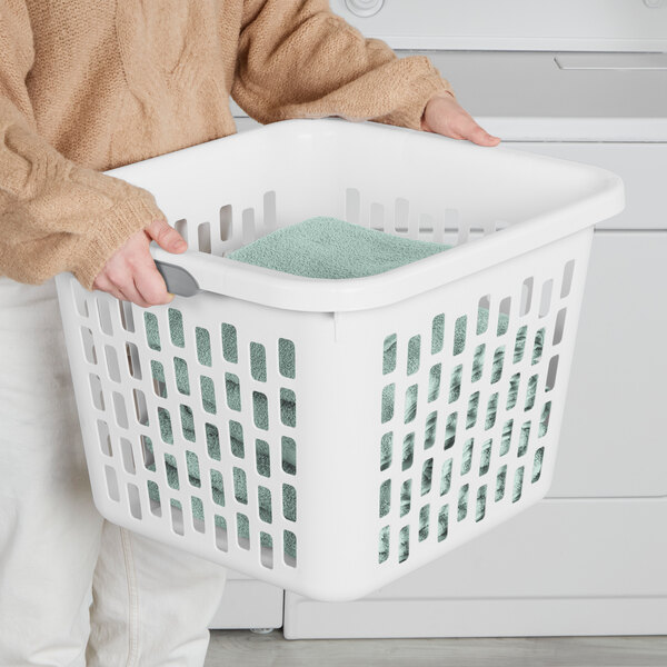A white square plastic laundry basket with handles, containing folded towels.