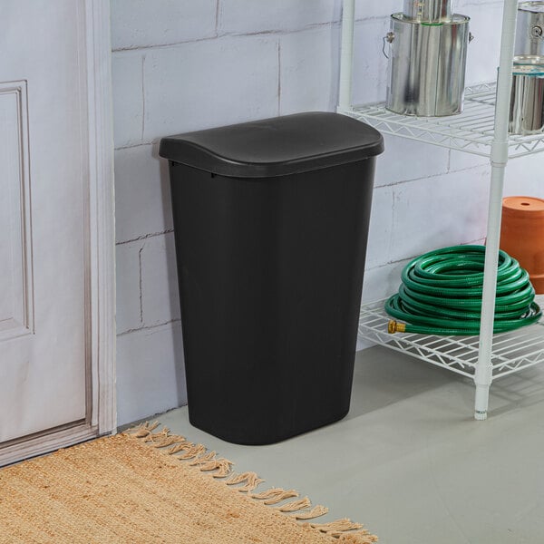 A black rectangular wastebasket with a lift-top lid.