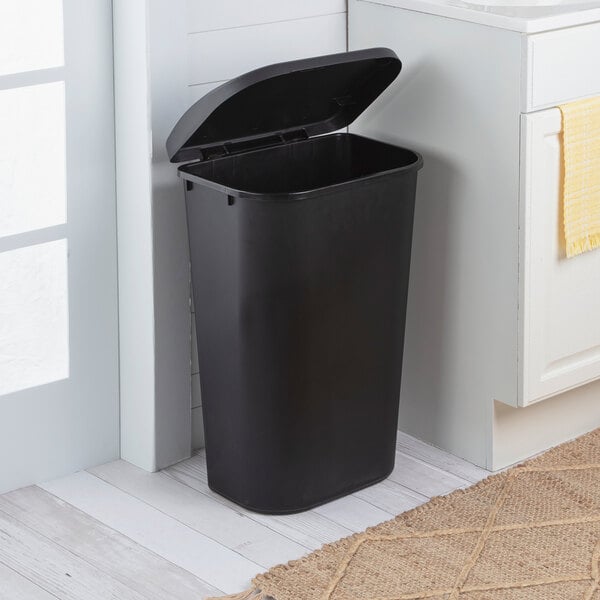 A black rectangular wastebasket with a lift-top lid.