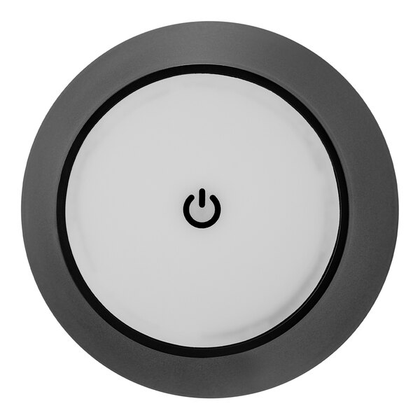 A round, black matte metal battery-powered LED lamp with a minimalist design and a power symbol in the center.