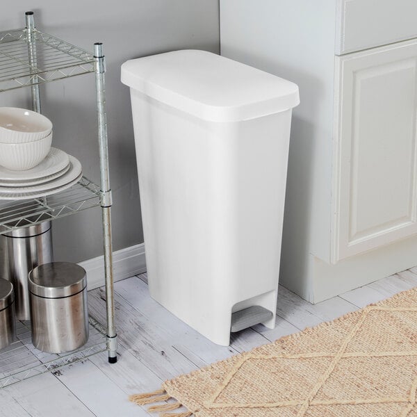 A slim white rectangular step-on wastebasket.
