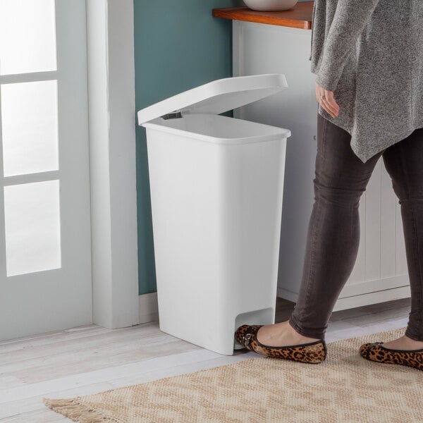 A slim white rectangular step-on wastebasket with a foot pedal and an open lid.