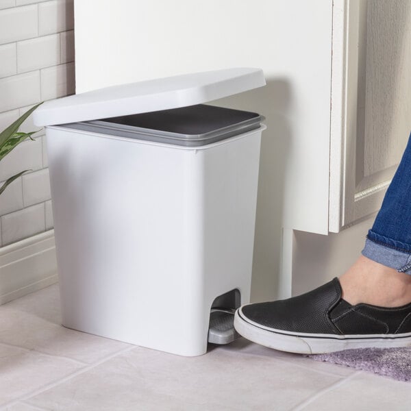 A white rectangular step-on wastebasket with a foot pedal and a partially open lid.