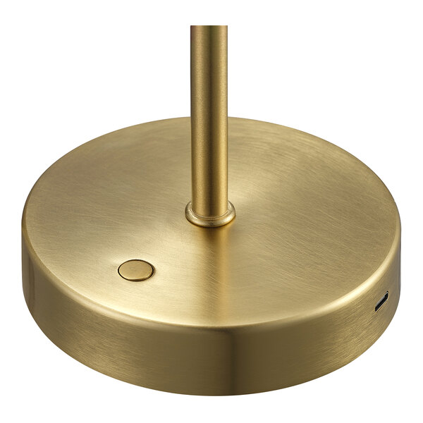 A matte brass base of a battery-powered LED table lamp with a button and a charging port.