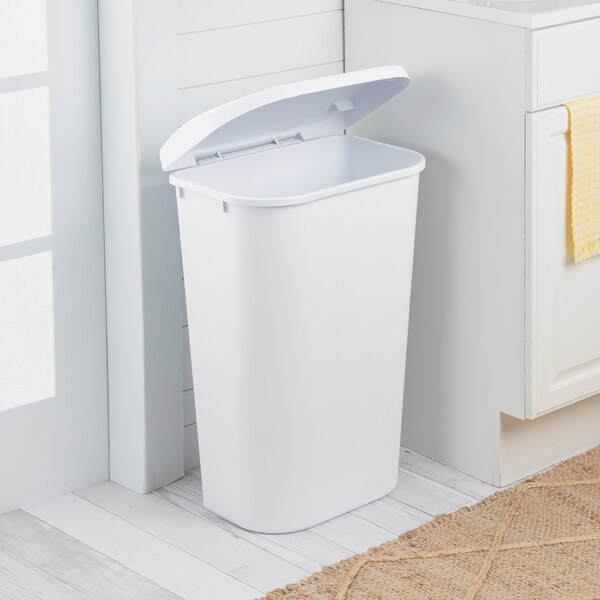 A white rectangular wastebasket with a lift-top lid.