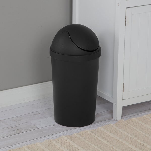 A black round wastebasket with a swing-top lid.
