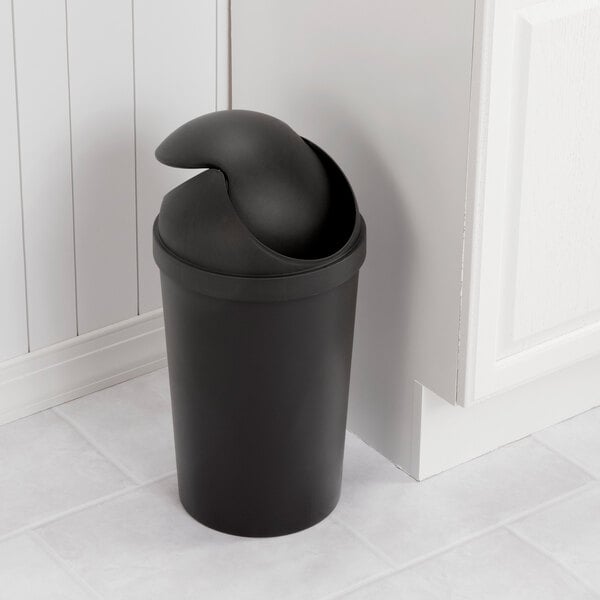 A black round wastebasket with a swing-top lid.