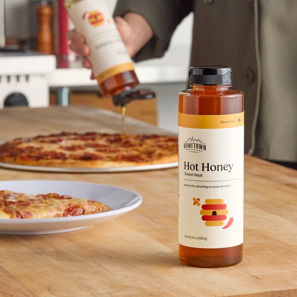 A 24 oz. squeeze bottle of Hometown Provisions Hot Honey placed on a kitchen counter.