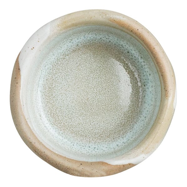 A small, round, organic stoneware ramekin with a natural, earthy glaze.