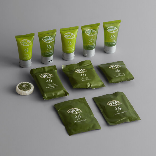 An 11-piece hotel amenity toiletries kit featuring various green-packaged personal care items including shampoo, conditioner, body wash, soaps, a shower cap, and a grooming kit.