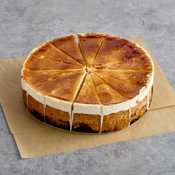A pre-cut 9-inch Irish coffee cheesecake with a caramelized top, divided into twelve slices and placed on parchment paper.