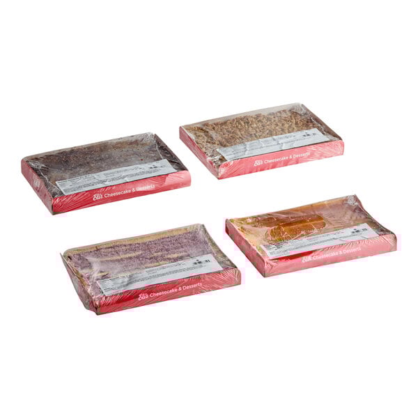 A set of four pre-cut cheesecake trays in assorted flavors, each wrapped in plastic and labeled, from Eli's Cheesecake.