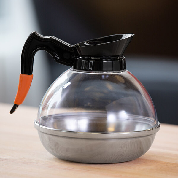 A clear plastic coffee decanter with a black handle and lid, and a stainless steel base.