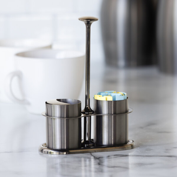 A stainless steel sugar stick holder and creamer set with a dark tungsten finish.