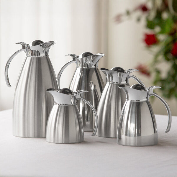 A brushed stainless steel insulated carafe with a flip-top lid and handle.