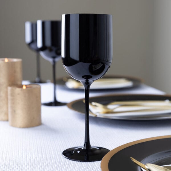 A black plastic wine goblet placed on a formal dining table setting.
