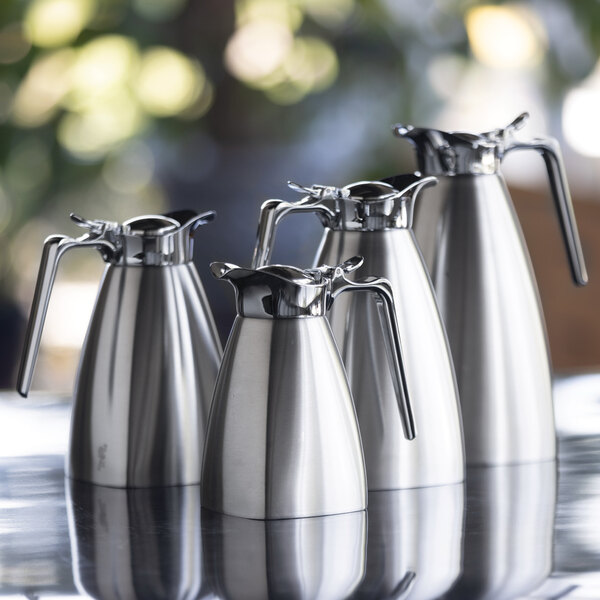 A set of stainless steel insulated coffee carafes with square bases and handles.