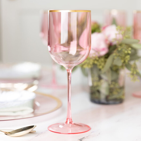 A pink plastic wine goblet with a gold rim.