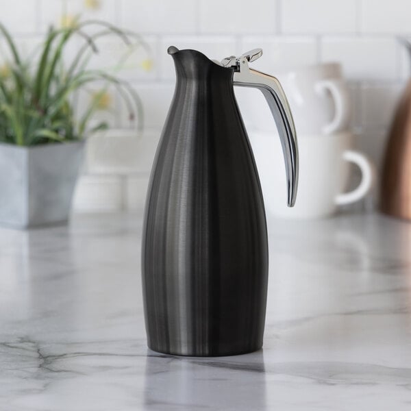 A black onyx stainless steel insulated coffee carafe server with a silver handle.