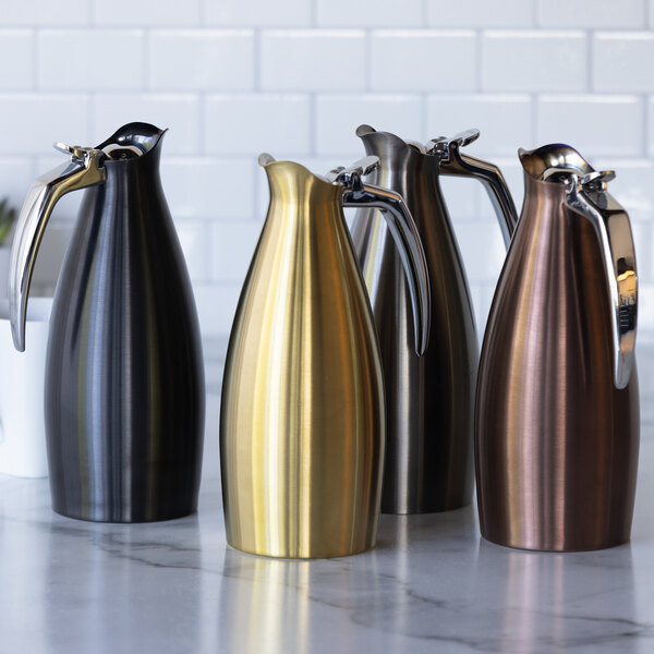A set of four stainless steel insulated coffee carafe servers in black, gold, bronze, and dark brown finishes.