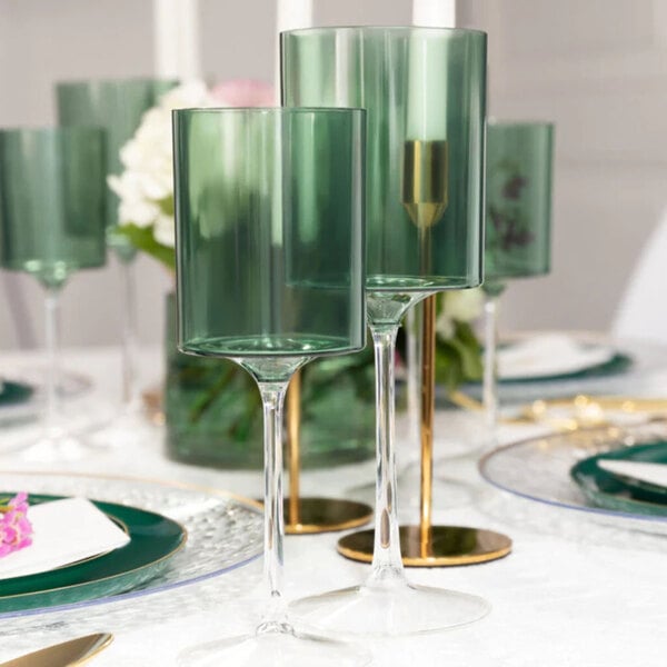 A set of two-toned green and clear plastic wine goblets displayed on a formal dining table.