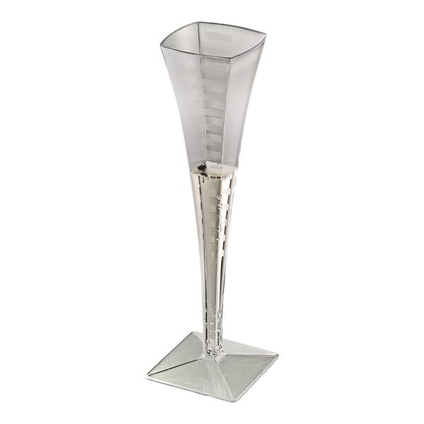 A clear, square-shaped plastic disposable champagne flute with a geometric base.