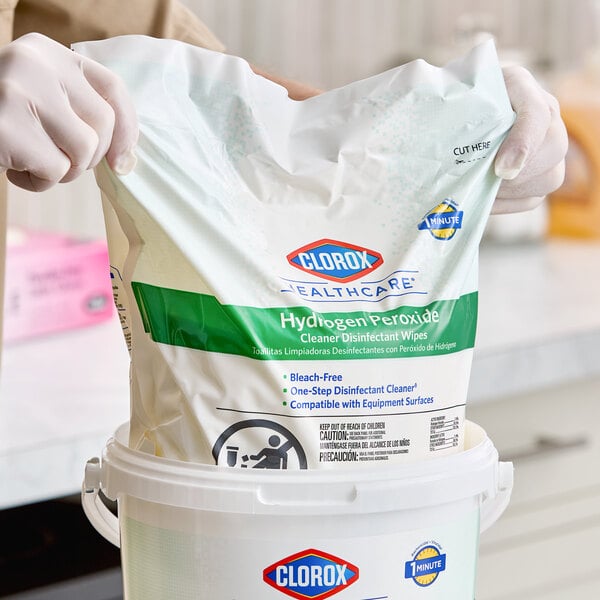 A refill pack of Clorox Healthcare hydrogen peroxide cleaner disinfectant wipes being placed into a container.