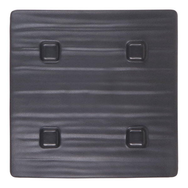 A square dark blue melamine plate with a textured surface and four indented square accents.