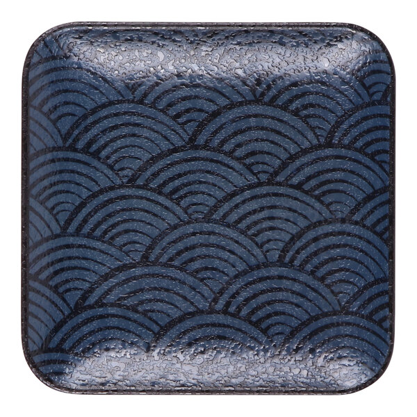 A square dark blue melamine plate with a wave-like pattern.
