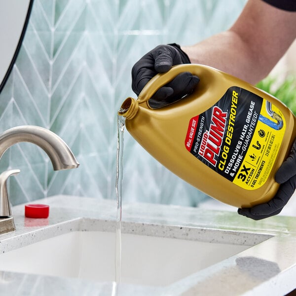 A person pouring Liquid Plumr Pro-Strength Clog Destroyer drain cleaner from a large gold bottle into a sink.