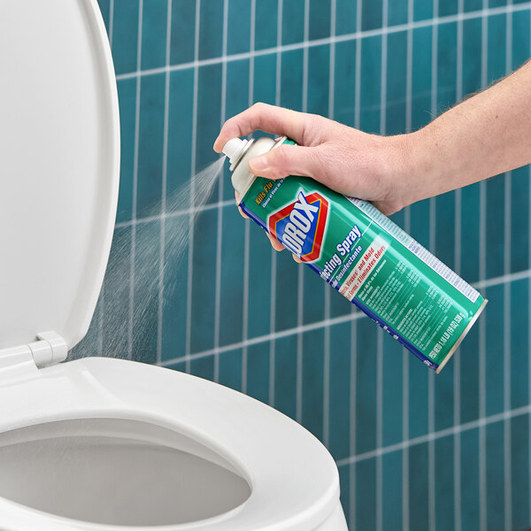 A can of Clorox disinfecting spray being used to clean a toilet.