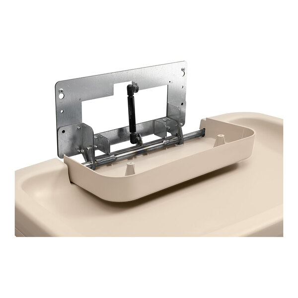 A cream-colored horizontal surface-mounted baby changing station with a visible metal hinge mechanism.